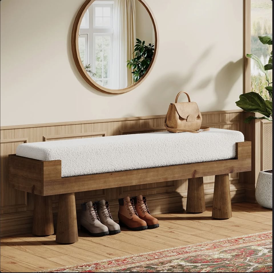 White upholstered bench with a warm brown wood frame in an entryway